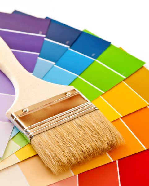 Clean paintbrush on rainbow of color card samples